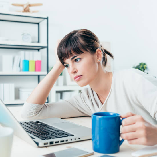 Woman at desk looking at laptop